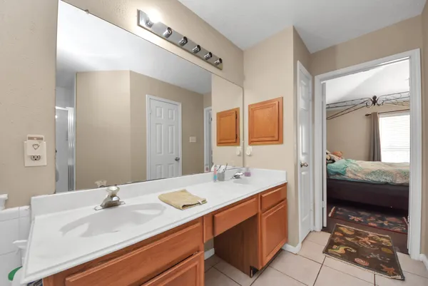 a en suite bathroom with a double vanity sink a mirror and next to a window