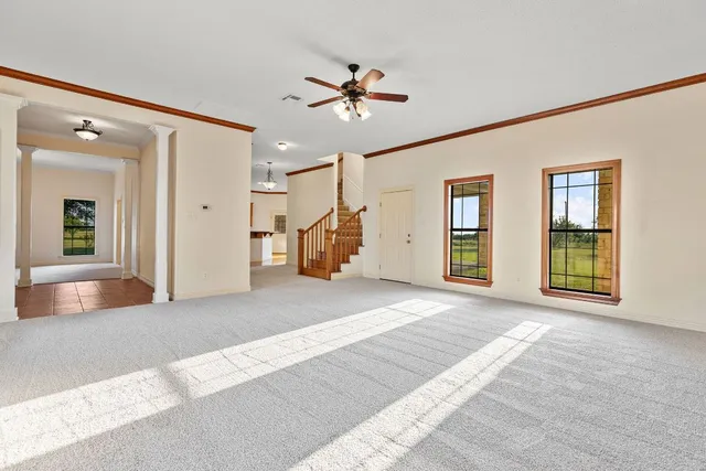 a view of an empty room with window and cabinet