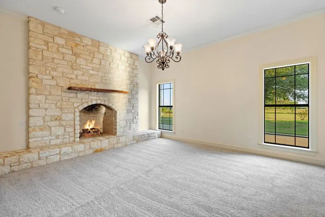 a view of an empty room with a fireplace and a window