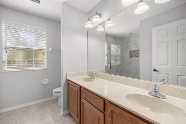 a bathroom with a double vanity sink and a mirror
