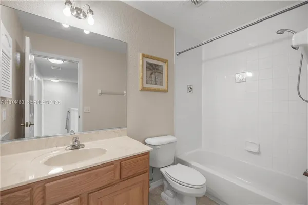 a bathroom with a sink a toilet and a large mirror