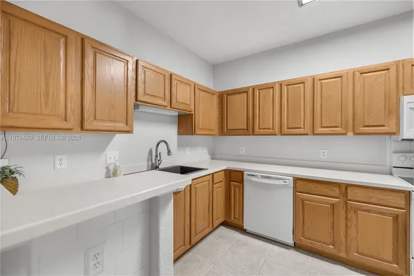 a kitchen with cabinets appliances a sink and a counter top space