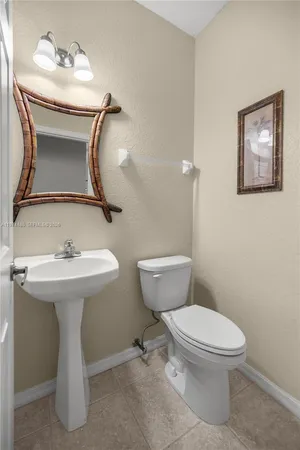 a bathroom with a sink toilet and a mirror