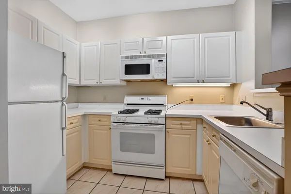 a kitchen with white cabinets and white appliances