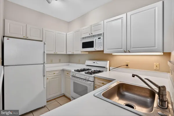 a kitchen with white cabinets and white appliances