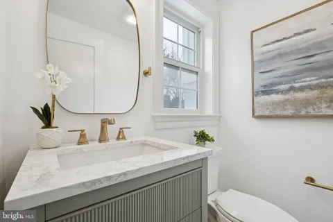 a bathroom with a sink a toilet and a mirror
