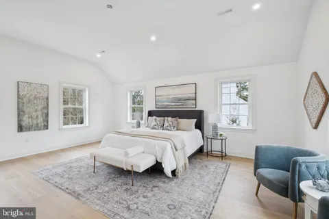 a spacious bedroom with a bed a couch and a window