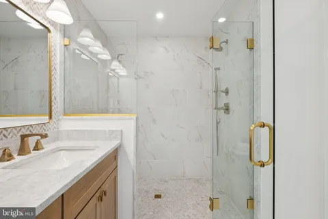 a bathroom with a granite countertop sink a shower and a mirror