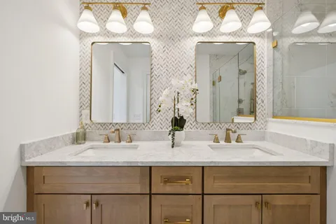 a bathroom with double vanity sinks and a mirror