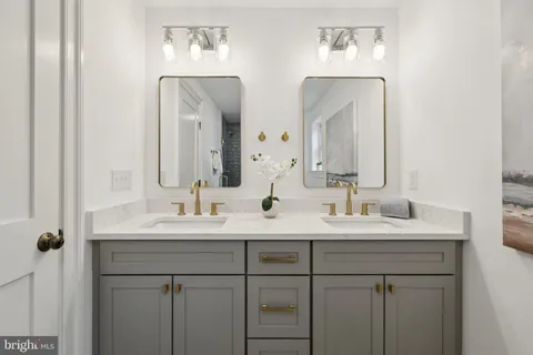 a bathroom with double vanity sinks and a mirror