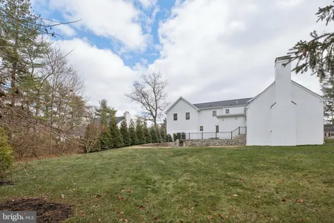 a big white house with a big yard and large trees