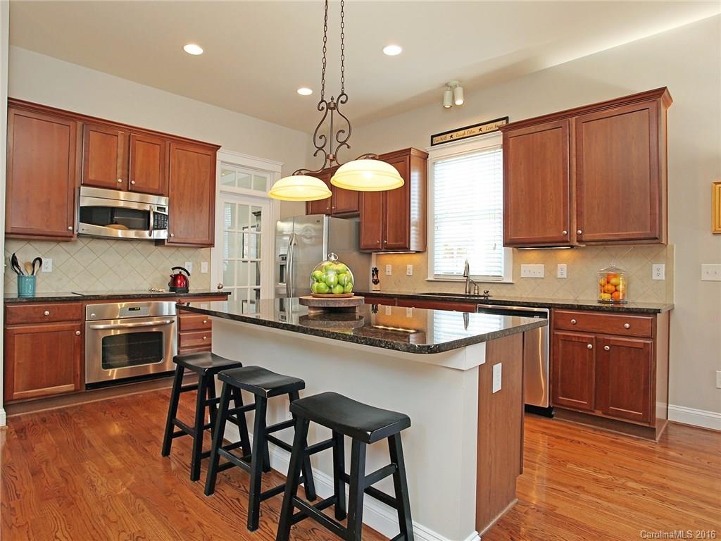 3542 Richard's Crossing Fort Mill, SC 29708 - Photo 11 of 24 a kitchen with stainless steel appliances a stove a sink a refrigerator cabinets and wooden floor