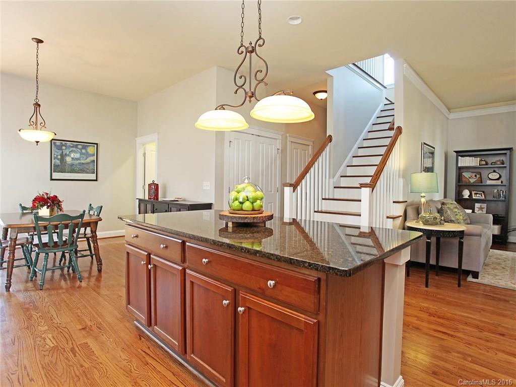 3542 Richard's Crossing Fort Mill, SC 29708 - Photo 12 of 24 a kitchen with granite countertop a table chairs stove and wooden floor