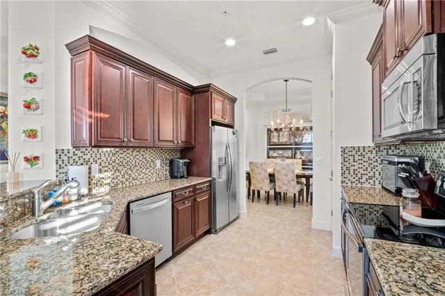 a kitchen with stainless steel appliances granite countertop a stove top oven a sink dishwasher and cabinets with wooden floor