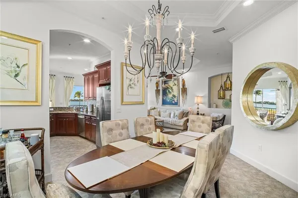 a living room with furniture a chandelier and a dining table