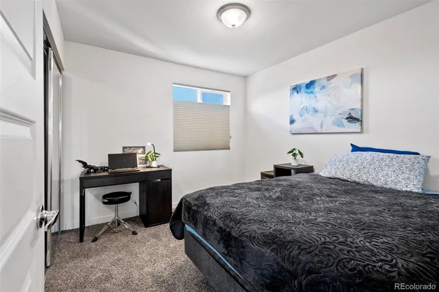 a bedroom with a bed and a desk