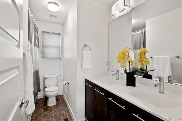 a bathroom with a double vanity sink toilet and a mirror