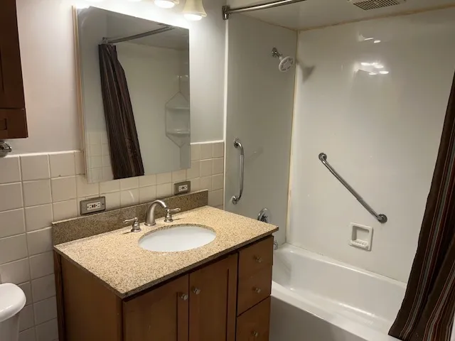 a bathroom with a granite countertop toilet sink and mirror
