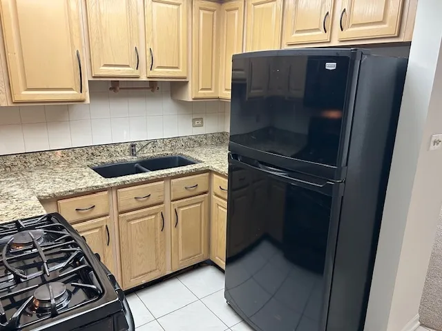 a kitchen with a sink a refrigerator and cabinets