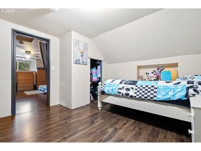 a bedroom with a bed and wooden floor