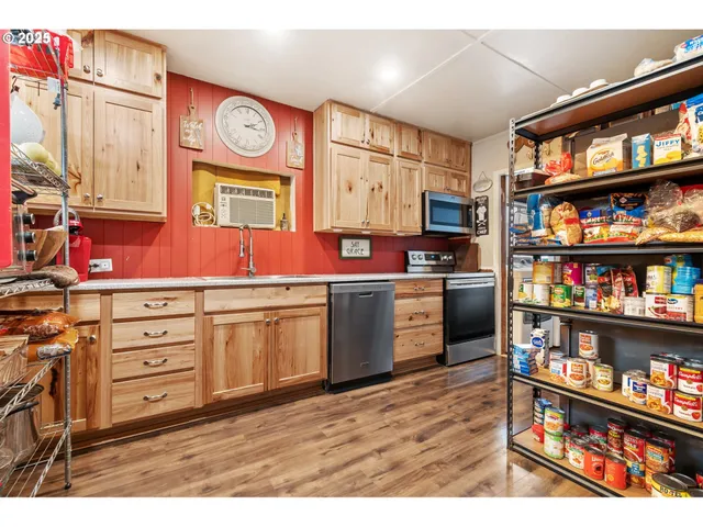 a view of kitchen with stainless steel appliances cabinets and a table