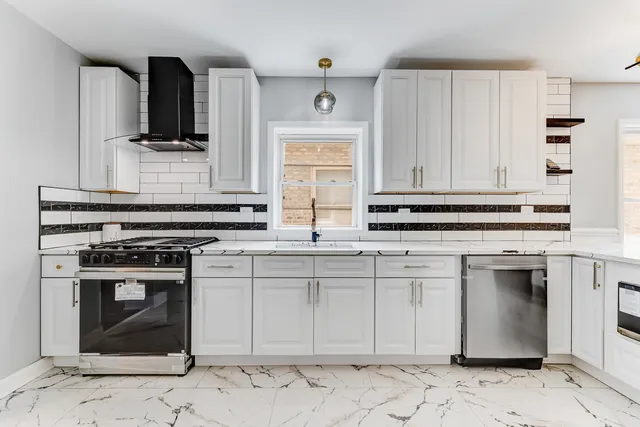 a kitchen with stainless steel appliances granite countertop a stove a sink and a microwave