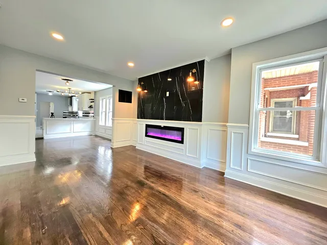 a view of a hallway with floor to ceiling window and living room