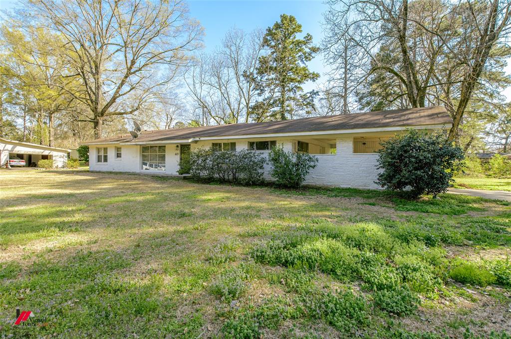 View of front of property featuring brick siding and a front lawn