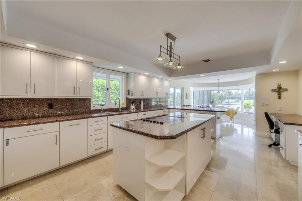 2260 Imperial Golf Course Boulevard Naples, FL 34110 - Photo 12 of 29 a large kitchen with kitchen island a sink and a stove in it