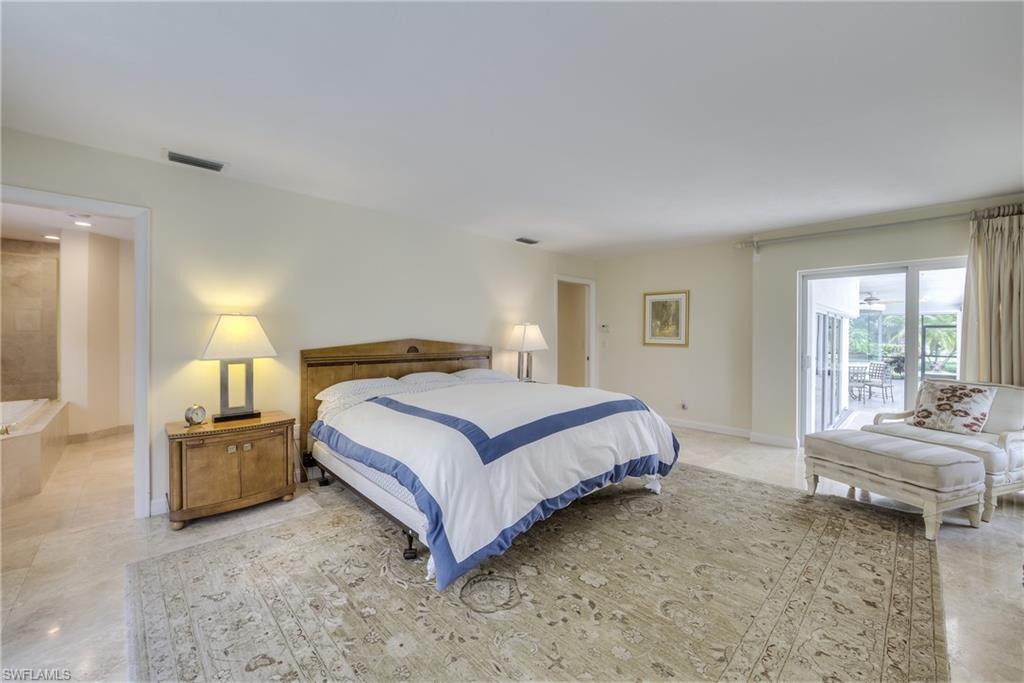 2260 Imperial Golf Course Boulevard Naples, FL 34110 - Photo 15 of 29 a spacious bedroom with a bed and wooden floor