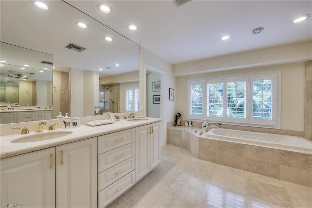 2260 Imperial Golf Course Boulevard Naples, FL 34110 - Photo 16 of 29 a large bathroom with a double vanity sink large mirror and a bathtub