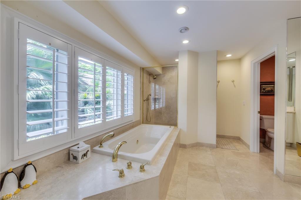 2260 Imperial Golf Course Boulevard Naples, FL 34110 - Photo 17 of 29 a bathroom with a tub a sink and a large window