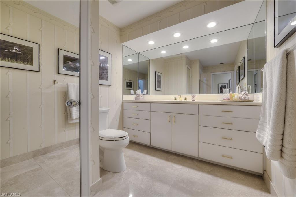 2260 Imperial Golf Course Boulevard Naples, FL 34110 - Photo 20 of 29 a bathroom with a double vanity sink toilet and a mirror