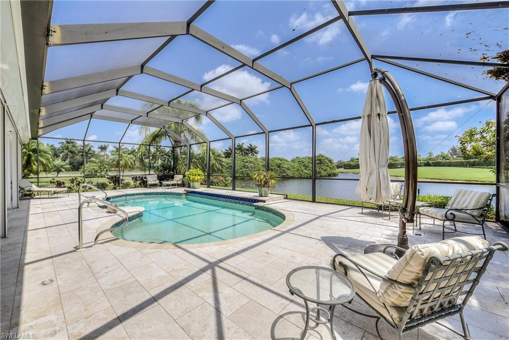 2260 Imperial Golf Course Boulevard Naples, FL 34110 - Photo 25 of 29 a patio with a yard table and chairs