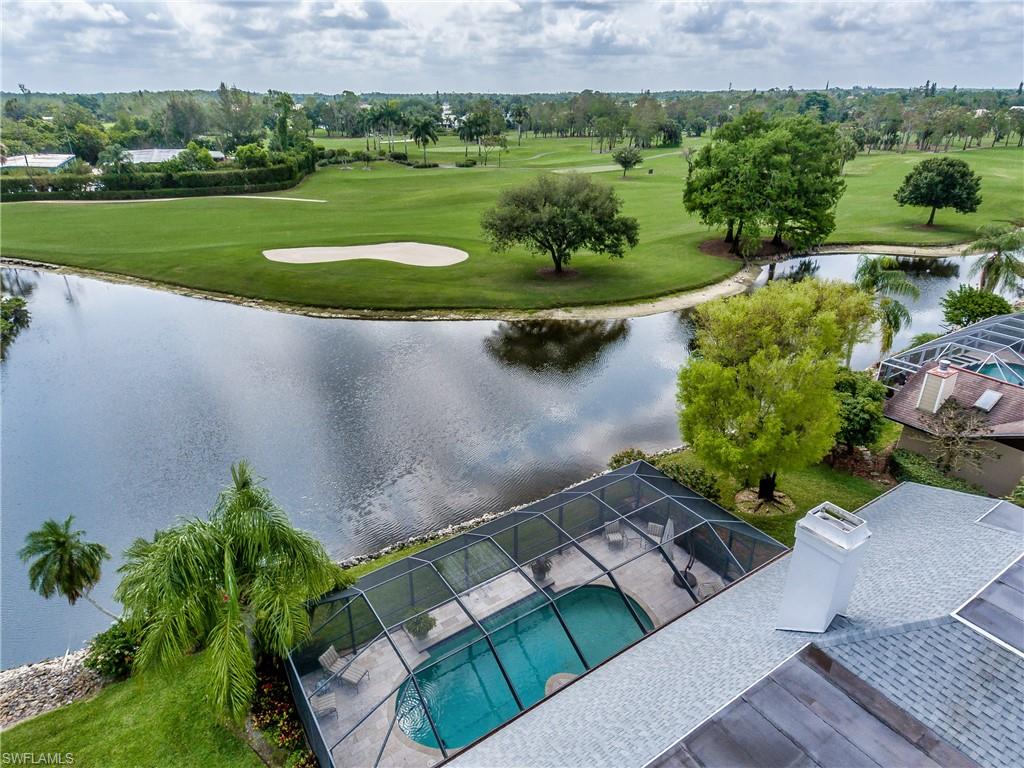 2260 Imperial Golf Course Boulevard Naples, FL 34110 - Photo 3 of 29 a view of a lake with a building in the background