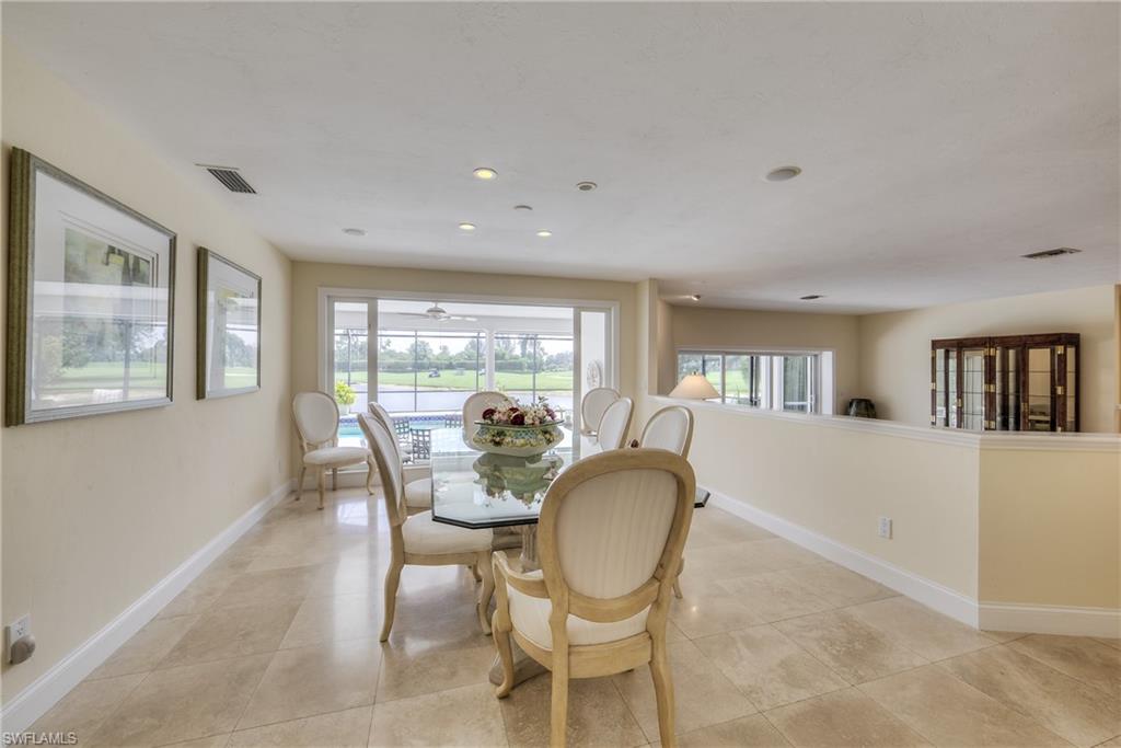 2260 Imperial Golf Course Boulevard Naples, FL 34110 - Photo 9 of 29 a view of a dining room with furniture a rug and wooden floor