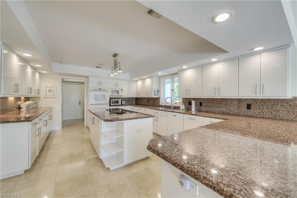 2260 Imperial Golf Course Boulevard Naples, FL 34110 - Photo 10 of 29 a large kitchen with stainless steel appliances granite countertop a sink a stove and a refrigerator