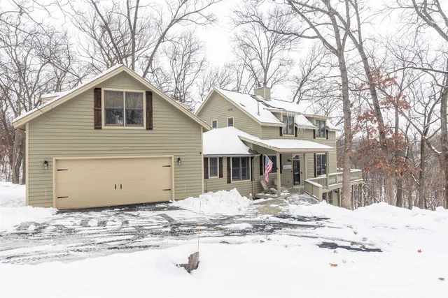 a front view of a house with a yard covered in snow