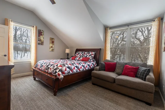 a bedroom with a bed couch and a large window