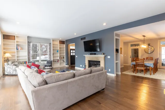 a living room with furniture floor to ceiling window hardwood floor and a flat screen tv