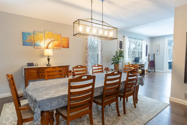a dining room with furniture a chandelier and wooden floor