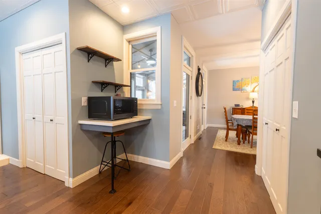 a view of hallway with livingroom and wooden floor