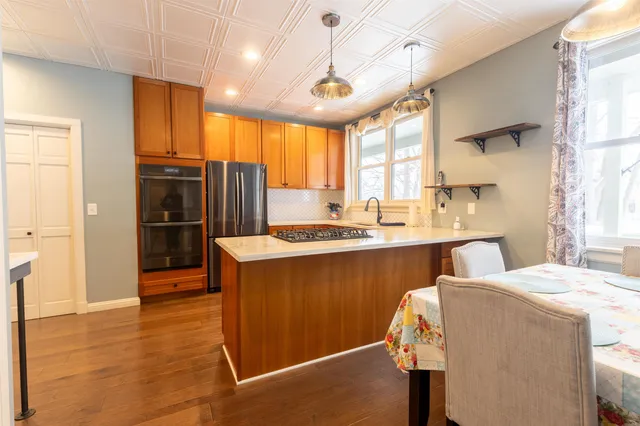 a kitchen with stainless steel appliances kitchen island granite countertop a refrigerator and a sink
