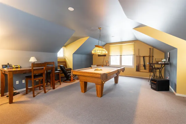 a living room with furniture and a pool table