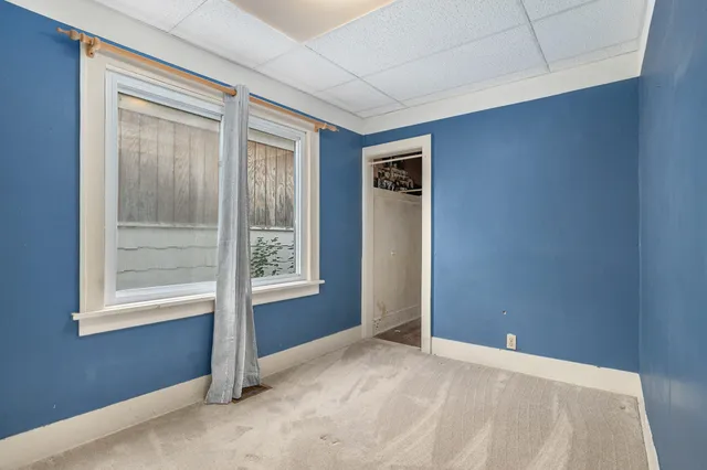 a view of an empty room with window and closet area