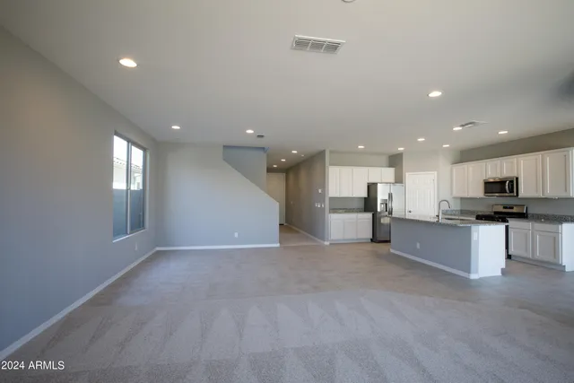 a large kitchen with a large counter top stainless steel appliances and cabinets