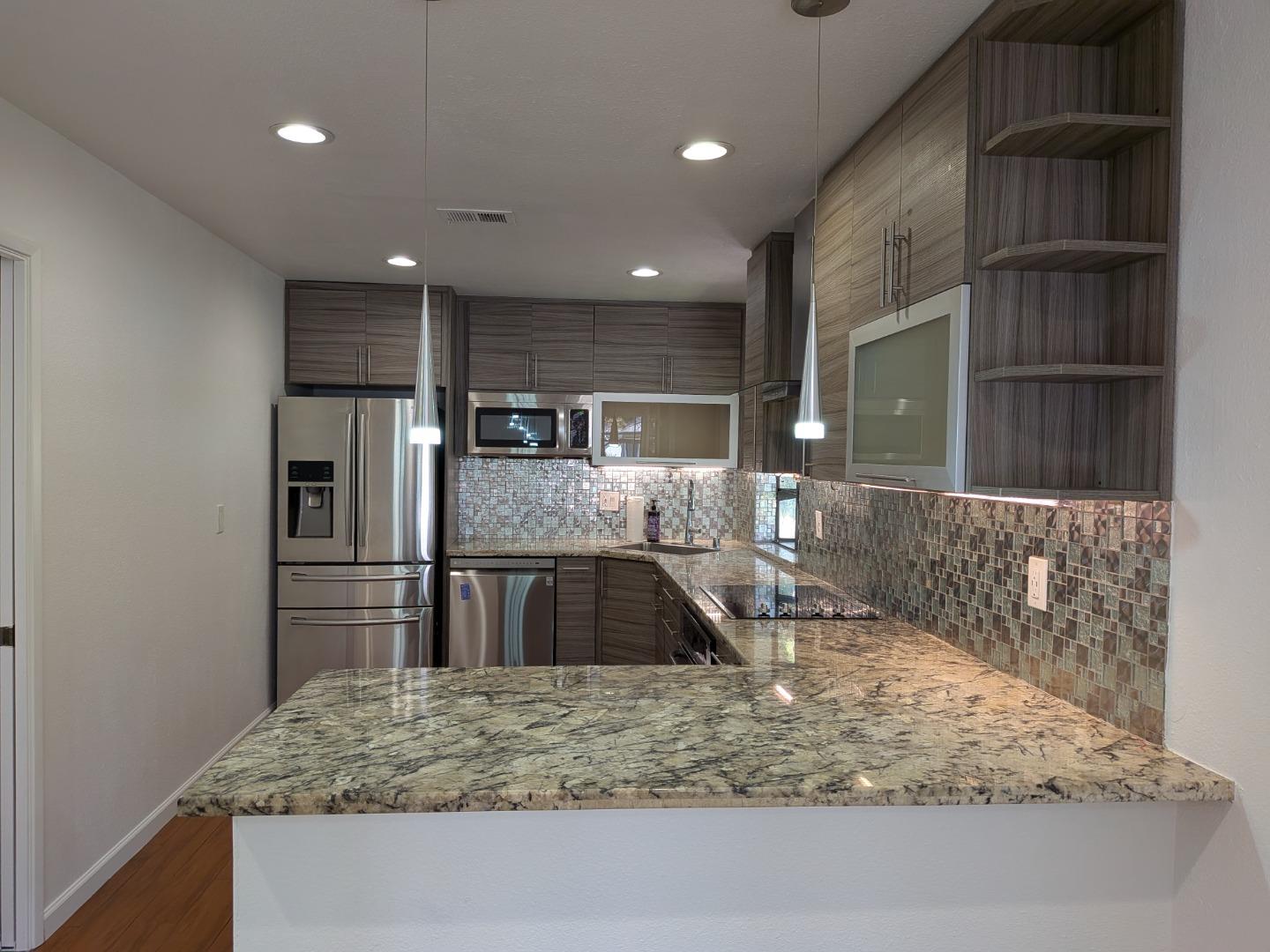 217 Ada Avenue, Unit 45 Mountain View, CA 94043 - Photo 12 of 43 a kitchen with kitchen island a sink and refrigerator