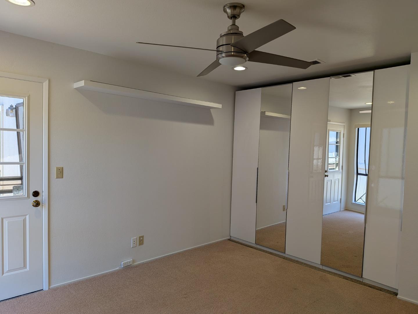 217 Ada Avenue, Unit 45 Mountain View, CA 94043 - Photo 30 of 43 an empty room with a mirror and a ceiling fan