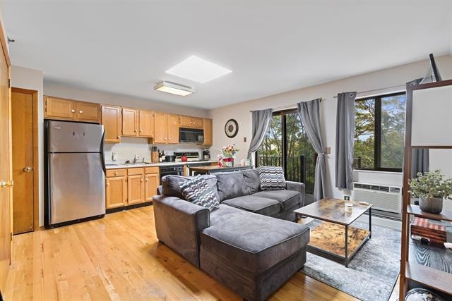 208 1st Street, Unit 5B Hoboken, NJ 07030 - Photo 2 of 11 a living room with furniture wooden floor and a refrigerator