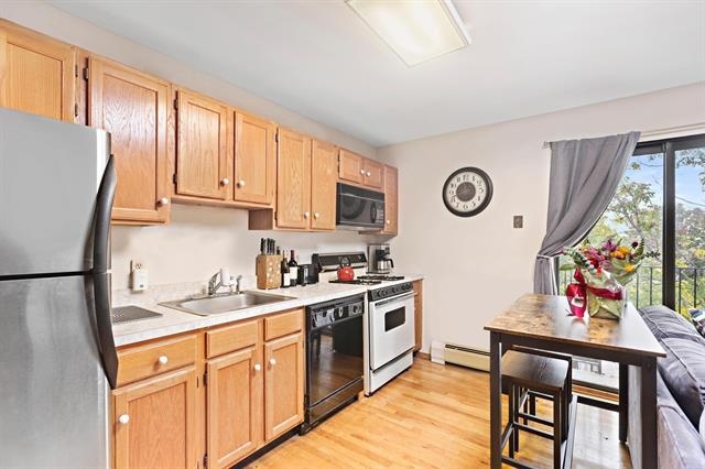 208 1st Street, Unit 5B Hoboken, NJ 07030 - Photo 7 of 11 a kitchen with stainless steel appliances granite countertop a refrigerator a stove a sink dishwasher and white cabinets with wooden floor